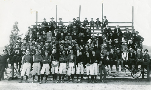 Large group of people including the Banning High School baseball team posing for photograph on bleachers