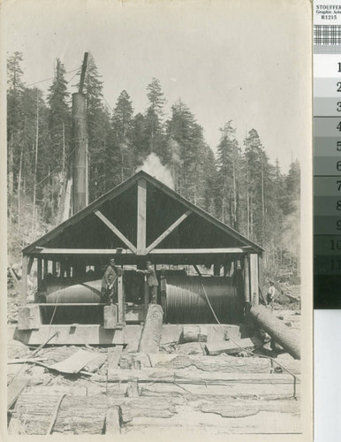 [Two winches in a shed with two posed workers]