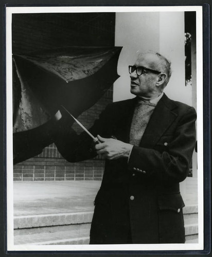 Photograph of Peter F. Drucker holding an umbrella