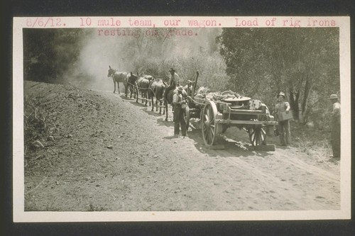 Ten mule team, our wagon. Load of rig irons resting on grade. August 6, 1912