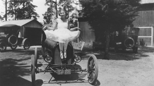 Mabel Franzen in butterfly costume sitting on Jim Smith's Model T hot rod, Santa Ana, California