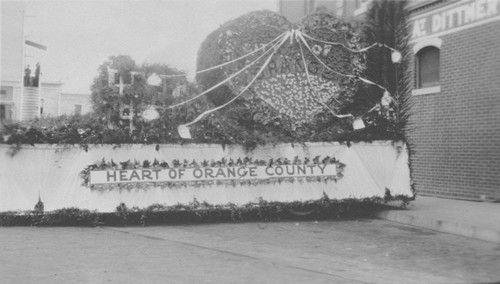 Armistice Day Parade with City of Orange Float, "Heart of Orange County", Orange, California, ca. 1920