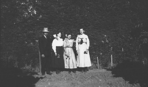 Henry William Hillebrecht with three young ladies in Hillebrecht garden, Orange, California, 1909