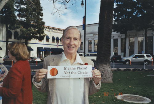 David Hart holdig sign, "It's the Plaza! / Not the Circle", Orange, California, 2002