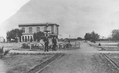 Plaza Park with two unidentified men near original fountain, Orange, California, 1887