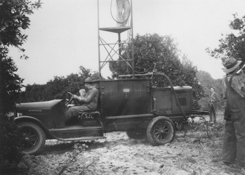 Spraying for insects in orange orchard, Orange, California, ca. 1925-1930