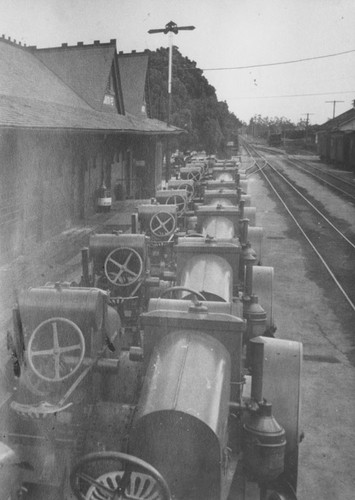 Santa Fe Depot with railroad car loaded with shipment of tractors for the M. Eltiste Company, Orange, California, 1922