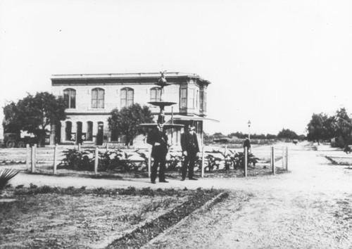 Plaza Park with two unidentified men near original fountain, Orange, California, 1887