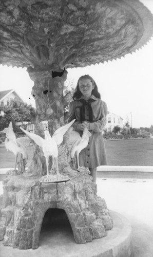 Elaine Davis by the original Plaza fountain after its move to Orange City Park, Orange, California, 1944