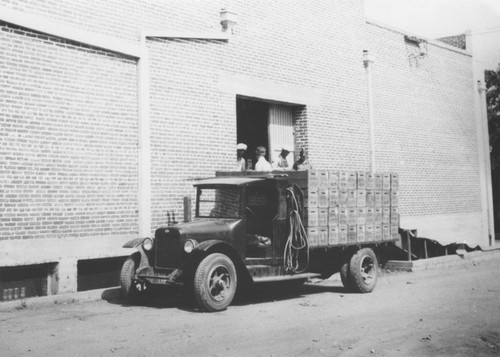 Truck loaded with citrus fruit at packing house door, Orange, California, 1930