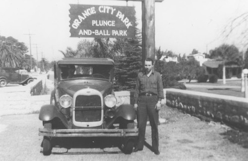 Orange City Park, with James R. Wann standing by automobile and park sign, Orange, California, 1930