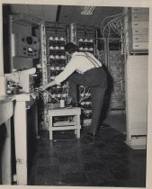 Man Working On Panel of Controls and Wires