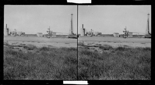 Gas Field, Corpus Christi, Texas. About the center of this view is seen an apparatus with many wheels for the purpose of opening valves. This is producing gas well & is commonly known as a x-mas tree. This sell produces dry & wet gas, also oil & salt water, hence the purpose of the tanks to the left is to separate the water from the oil & the round, upright contraption connected by pipe with the little house is for separating the dry from the wet gas. To the extreme right you will see a new well being drilled. #41