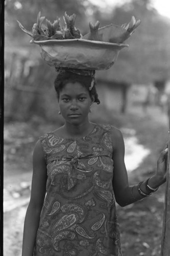 A woman balances a metal bowl on her head, San Basilio de Palenque, 1975