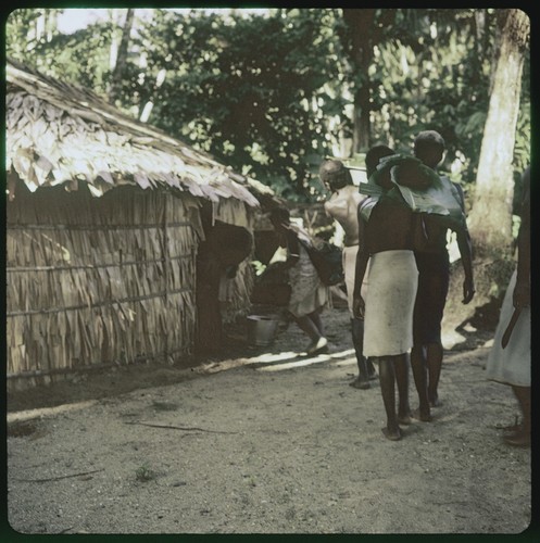 Men and women walking and carrying objects