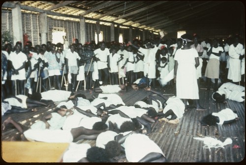 Several people on the floor in trance, in front of spectators, and Holy Mama