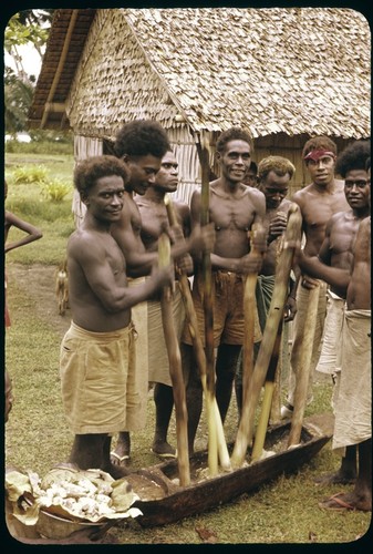 Men mashing up taro root