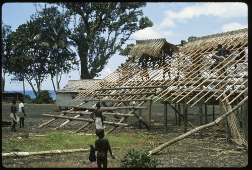 Men weaving roof of building