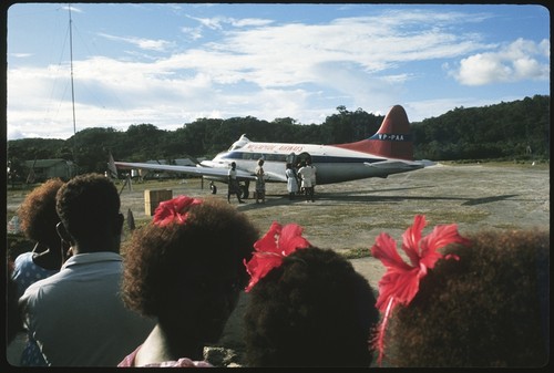 Group watch as Frances Harwood and others board airplane