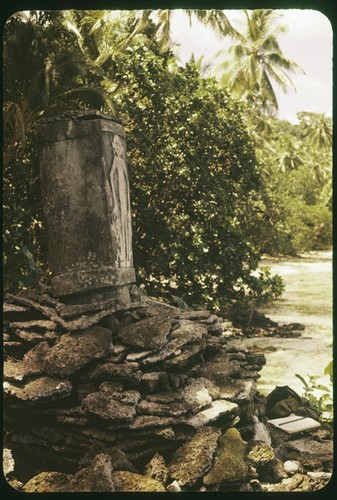 Dolo or burial urn chisled from a single block of limestone and set upon a pyramid of coral slab