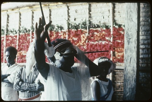 Holy Mama in a building with flower covered wall in background