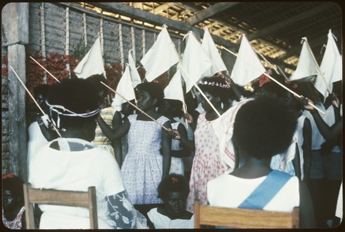 Group of people holding white flags in front of Holy Mama