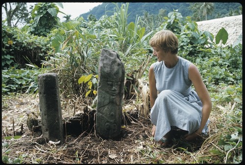 Anne Scheffler sitting beside a grave carving