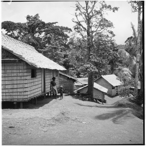 Woman and child by house, in village