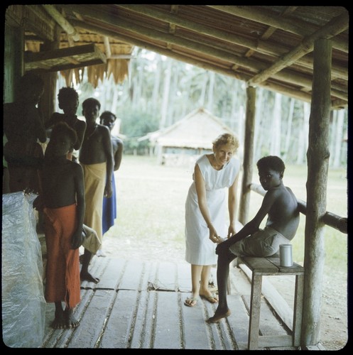 European woman wrapping boy's foot