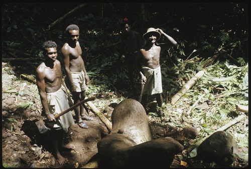 Men in forest with petroglyph