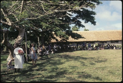 Group in a field outside a large building