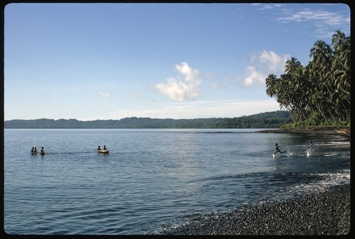 Children on canoes, playing on the beach