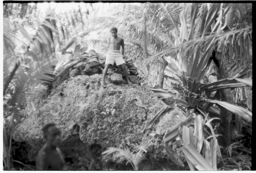 Man on shrine on top of coral outcropping