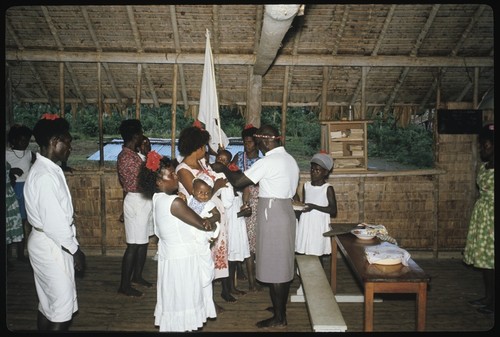 Group in a building; woman holding a white flag