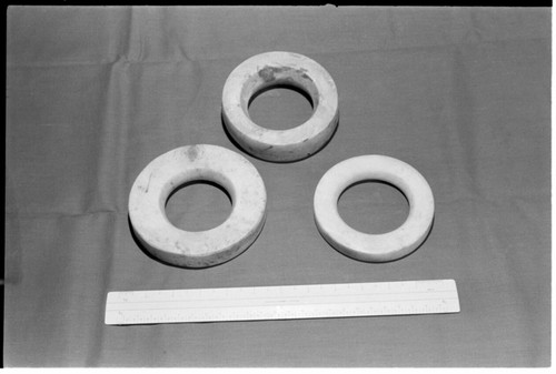 Three shell ring valuables, shown with ruler for scale