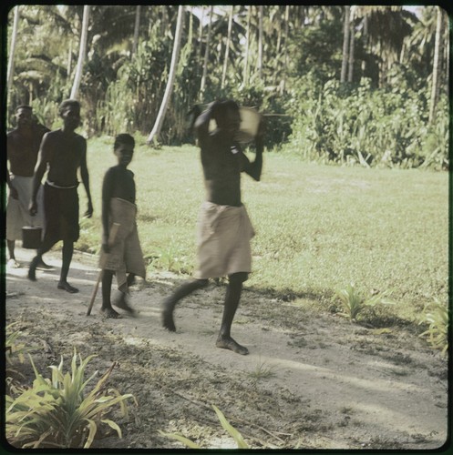 Men and boys walking and carrying objects