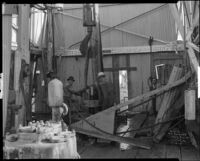 Two workers at the travelling block of an oil well, probably at the Venice or Playa del Rey oil field, Los Angeles, 1930