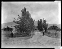 Two men, house and barn in valley, California