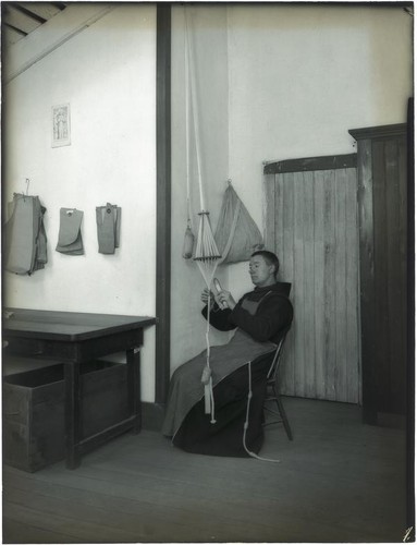 Monk working on cord-making at the Mission Santa Barbara, Santa Barbara, 1898