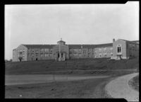 Exterior view of an unidentified building (school?), with a hexagonal tower, California