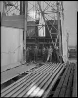 Group portrait of men at the base of an oil well at the Venice or Playa del Rey oil field, Los Angeles, circa 1930