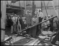 Group portrait of men and women on the drill floor of an oil well, at the Venice or Playa del Rey oil field, Los Angeles, circa 1930