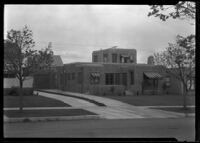 Exterior view of an unidentified house with striped awnings, California