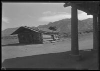 Log building with sign for Bishop Drug Co., vicinity of Bishop