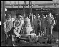 Workers gathered around a casing elevator at an oil well, probably at the Venice or Playa del Rey oil field, Los Angeles, 1930