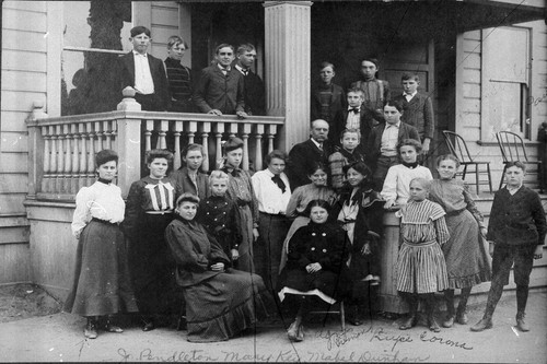 Photograph of teachers and schoold children standing on porch of Placentia Union Grammar School
