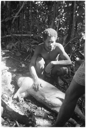 Taaboo tending fire to cook the sacrificial pig