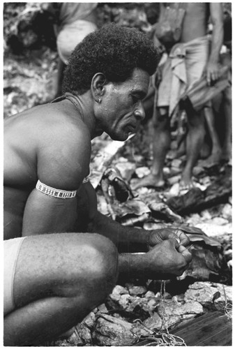 Larikeni of Furingudu measuring out kofu shell money to purchase packets of fish at market with sea people