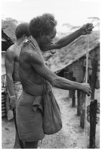 Elota counts strings of shell he is presenting as bride-price for his marriage to Tege