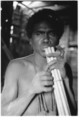 Young man plays sukukwaakwaa bundled bamboo flute